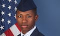 Man in air force uniform stands in front of American flag and blue background