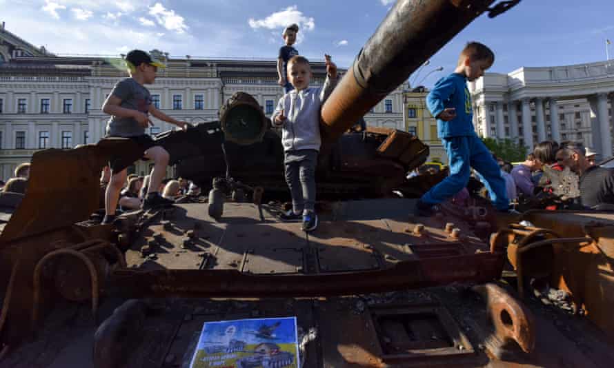 Children climb on a burned Russian tank
