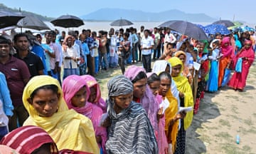 Voters queue to cast their election ballot outside a village polling station in Assam state