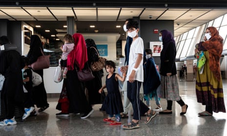 Refugees from Afghanistan are escorted to a waiting bus after arriving at Dulles international airport in Virginia, US