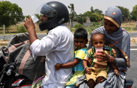 An Indian family drink free sweet water on a highway during a hot afternoon at Garhi village in the northern Indian state of Haryana. With temperatures hitting 50C, the country has seen several deadly heatwaves in recent years.