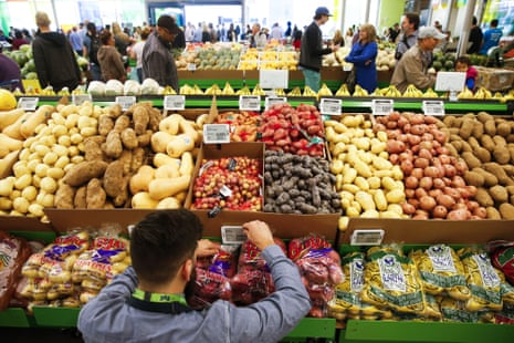 An employee arranges a digital price tag for vegetables