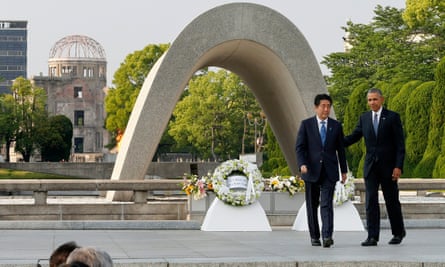 Barack Obama and Shinzo Abe walk after laying wreaths in front of a cenotaph to offer prayers for victims of the atomic bombing in 1945 at Hiroshima Peace Memorial park.