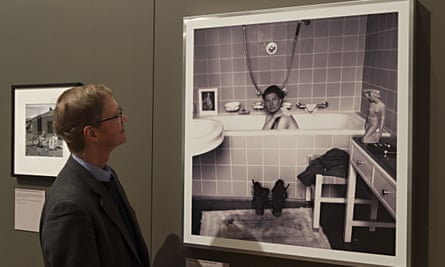 Tony Penrose in front of a photograph of his mother in Hitler’s bath, taken in April 1945, and currently on show at Lee Miller: A Woman’s War at the Imperial War Museum, London
