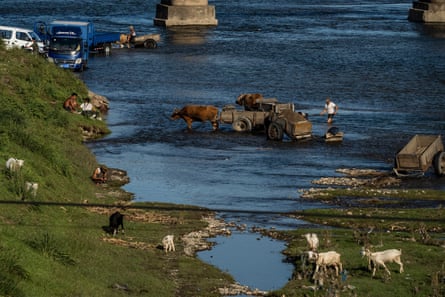 People wash cars and collect gravel at a riverbank between Ulim Waterfalls and Hamhung in the country’s east