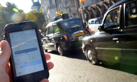 An Uber customer uses the phone app at a black-taxi rank in London.