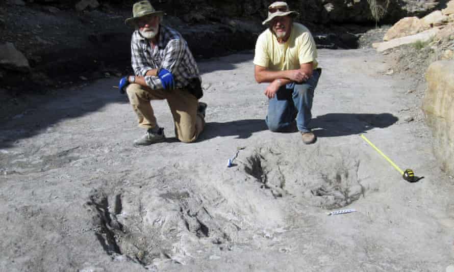 Martin Lockley and co-author Ken Cart kneeling beside two large Cretaceous-age scrapes from western Colorado.