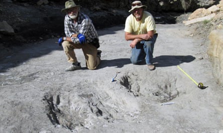 Martin Lockley and co-author Ken Cart kneeling beside two large Cretaceous-age scrapes from western Colorado.