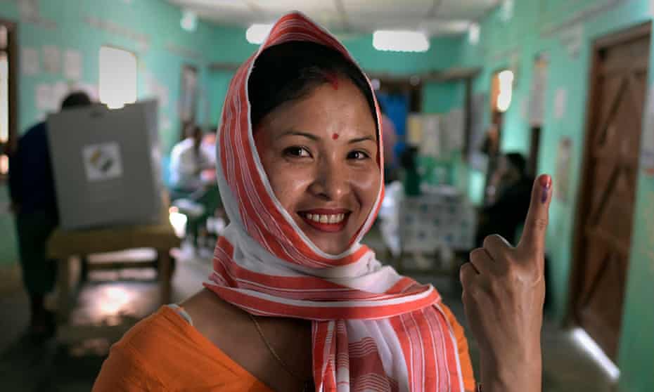 A woman shows her ink-marked finger after casting her vote in Jorhat district of Assam