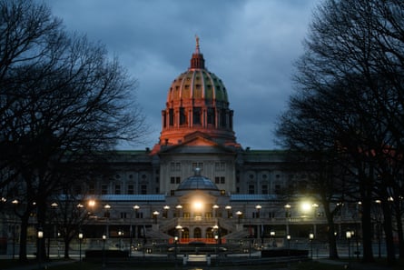 Exterior of a large building with a warmly lit dome at nighttime