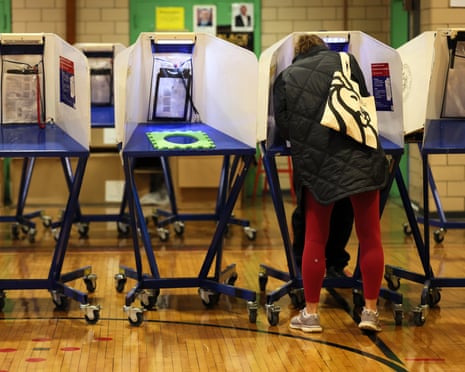 a person stands in a voting booth