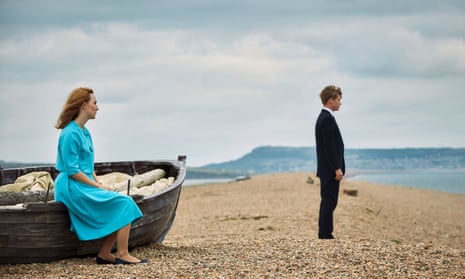 Saoirse Ronan as Florence and Billy Howle as Edward in the film On Chesil Beach. They stand looking out to sea on the beach. Dorset, UK.