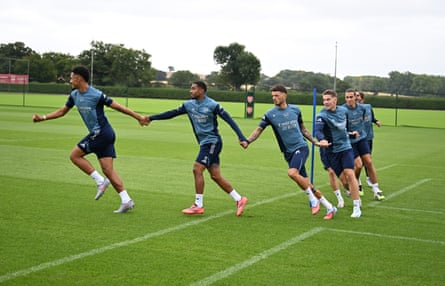 Arsenal players hold hands in training