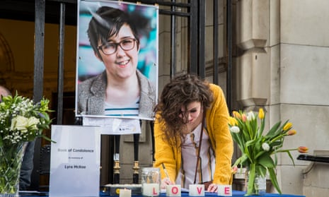 A woman signs a book of condolence after a vigil at Belfast City Hall in memory of the journalist Lyra McKee