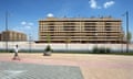 A man talks on his mobile phone as he walks a deserted street backdropped by newly built apartment buildings in Seseña