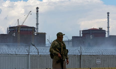 A serviceman with a Russian flag stands guard near the Zaporizhzhia nuclear power plant outside the Russian-controlled city of Enerhodar.