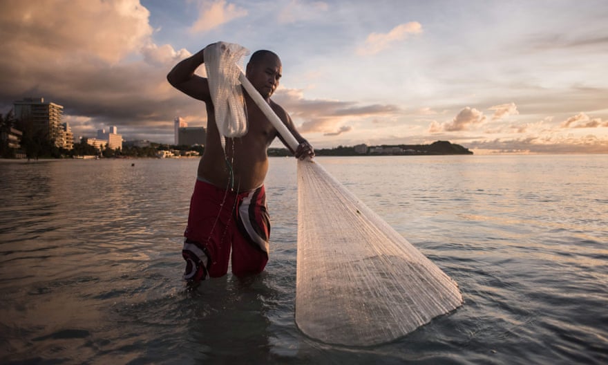 A fisherman catches ‘goat fish’ off a beach in Guam.