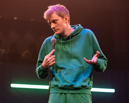 James Acaster onstage in green tracksuit