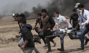 A wounded youth is carried on a stretcher by running men