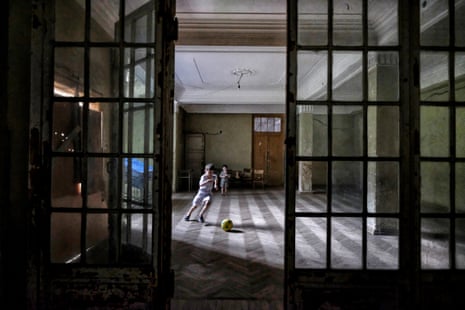 Two children play in a grand corridor