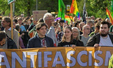 Demonstrators walk behind a banner saying ‘antifascism’ at a rally in Dresden.