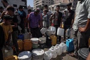 Crowd of people with water containers lined up