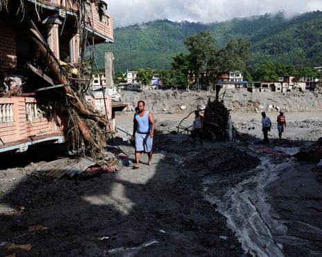 People move through a mud-coveredroad in Trishuli in Nepal's Nuwakot district