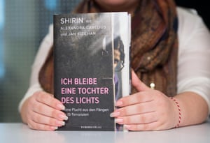 The Yazidi author, writing under her pseudonym Shirin, holds her new book in her hands, titled ‘Ich bleibe eine Tochter des Lichts’ (I remain a daughter of light), during a book presentation in Munich