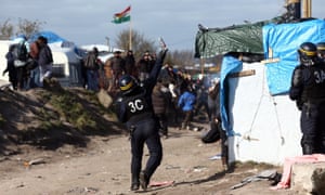 A police officer throws teargas as part of the ‘jungle’ migrant camp is cleared.