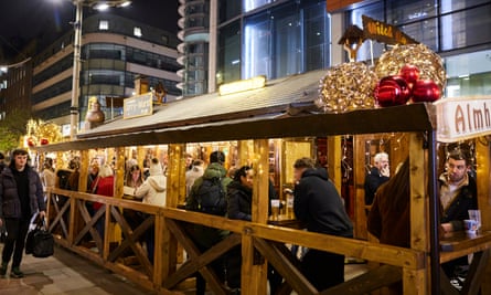 People gather inside stalls at a Christmas market