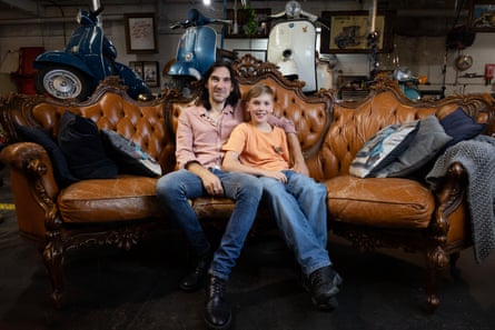 Mario Gabrieli with his son Leonardo sitting on a lounge at the scooter mechanics in Sydney with their blue Vespa in the background