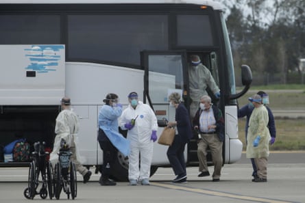 Passengers from the Grand Princess cruise ship exit a bus before boarding a chartered flight to San Antonio, Texas.