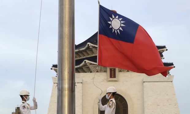 Two soldiers lower the national flag in Taipei, Taiwan
