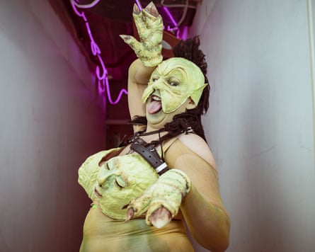 He wears a green suit with faces incorporated into it