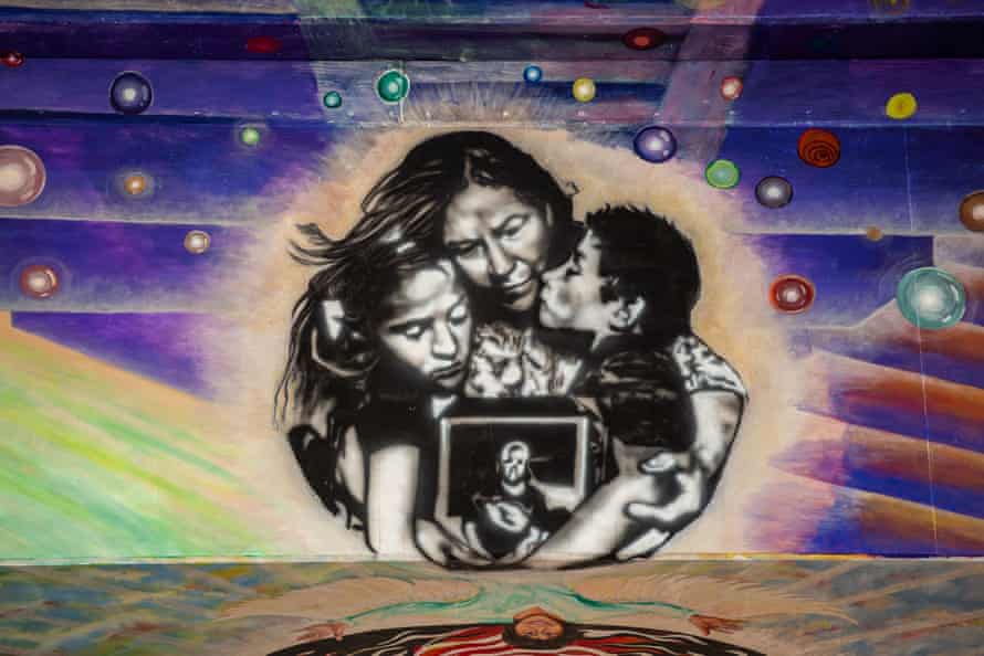 painting of family holding a picture and embracing