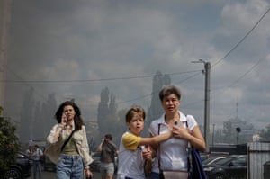 A woman and child looks distressed as they flee the scene of an air strike in Kharkiv
