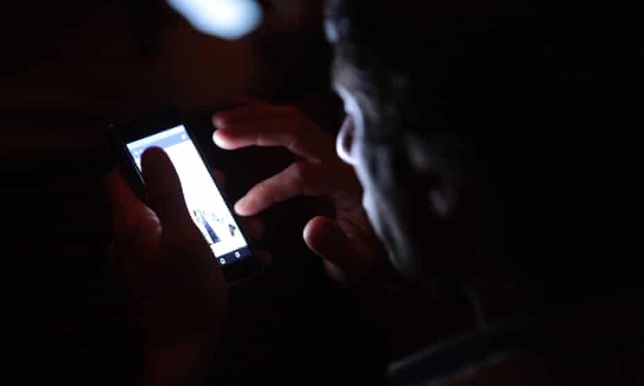 man uses phone in dark