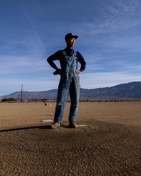 Dan Kwong stands on the old pitcher's mound at Manzanar, mountains in the distance