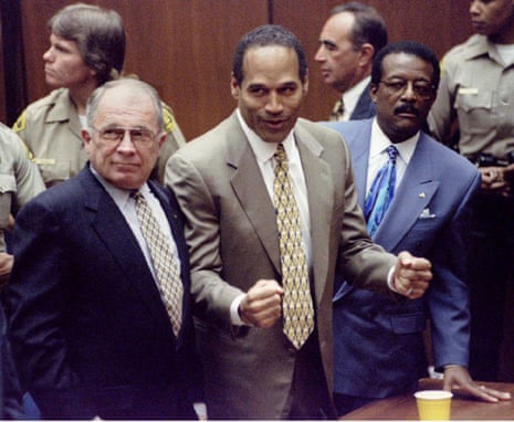 man clenches his fists smiling, flanked by two other men