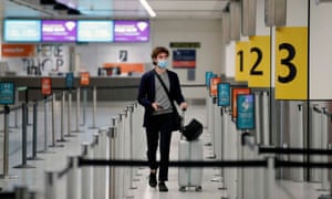 A passenger wearing a face mask arrives at the check-in counters at an almost empty Gatwick Airport, amid the coronavirus disease (COVID-19) outbreak.