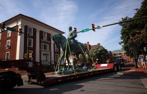 A flatbed truck carries a statue of Confederate General Robert E Lee from the Market Street Park in Charlottesville