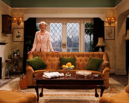 Woman stands behind sofa in 70s-style room