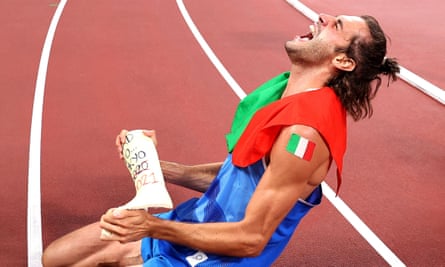 Italy’s Gianmarco Tamberi holds his cast as he celebrates following the men’s high jump final at the Tokyo 2020 Olympic Games