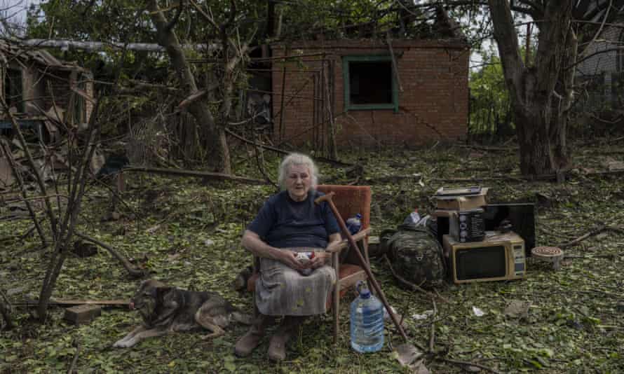 Elena Holovko sits among debris outside her house damaged after a missile strike in Druzhkivka, eastern Ukraine, on Sunday.