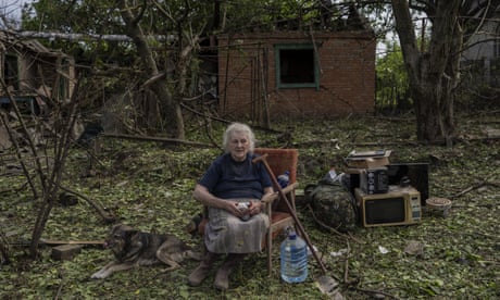 Elena Holovko sits among debris outside her house damaged after a missile strike in Druzhkivka, eastern Ukraine, on Sunday.