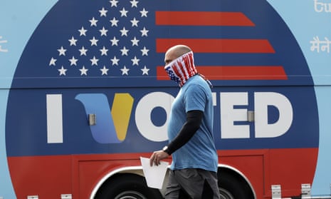A man wears a mask as he walks to cast his vote.