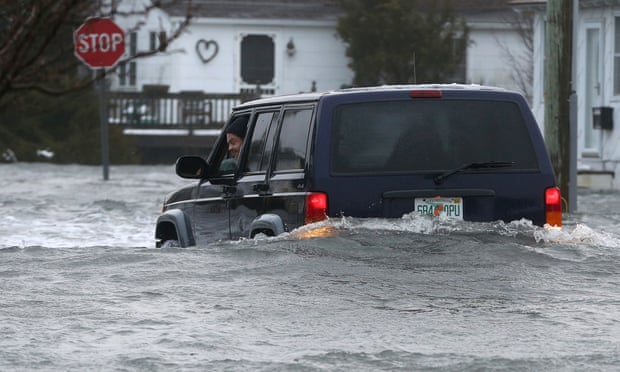 The driver of an SUV looks out of his window on a flooded 10th Ave. in North Wildwood, N.J., at the height of the storm, later backing down the street, Saturday, Jan. 23, 2016. A winter storm created near record high tides along the Jersey Shore, surpassing the tide of Hurricane Sandy according to North Wildwood city officials. (Dale Gerhard/Press of Atlantic City via AP)