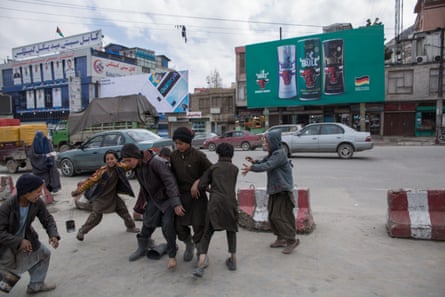 A street in Kabul with a billboard advertising soft drinks in the background.