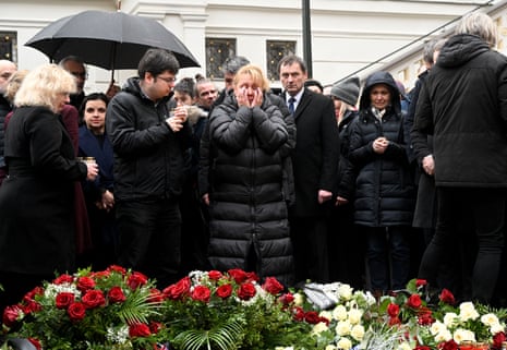 People mourn at a makeshift memorial for the victims outside the Charles University in central Prague, on December 22, 2023, as police investigators kept working on the campus the day after a deadly mass shooting.