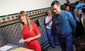 Begoña Gómez preparing to cast a vote with Pedro Sánchez standing behind her